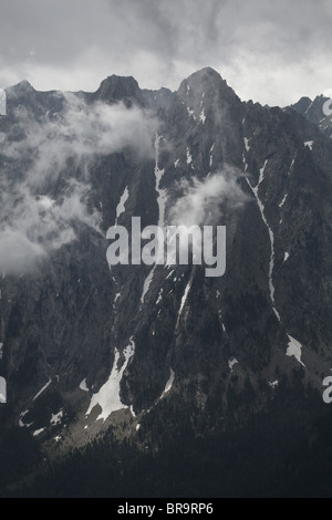 Rising nebbia nube bassa volute intorno Els Encantats peak vista da d'Amitges in Sant Maurici Parco Nazionale Pirenei Spagna Foto Stock