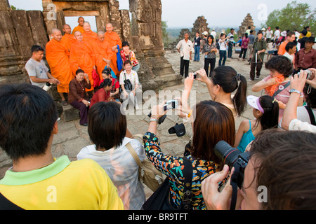 I turisti posano per le foto con i monaci a Angkor Wat Cambogia. Foto Stock