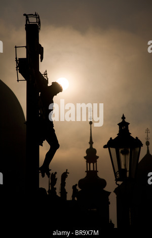 Praga - croce da H. Hilger 1629 sul Ponte Carlo da sunrise - silhouette Foto Stock