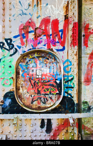 Strati colorati di graffiti su un treno in disuso bridge Foto Stock