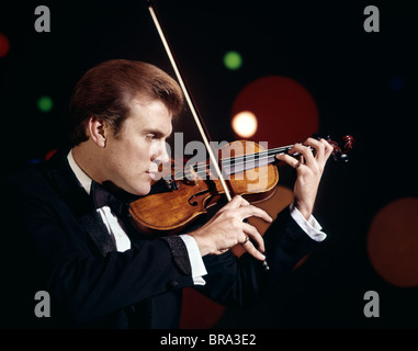 1960 anni sessanta retrò uomo che indossa lo smoking suona il violino musicista di musica classica Foto Stock