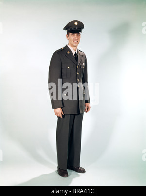 Dagli anni sessanta a piena lunghezza Ritratto soldato permanente sorridente esercito uniforme Foto Stock