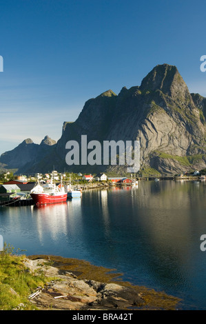 L'Europa, Norvegia Lofoten. La comunità di Reine sotto il glacially sculped Olstinden di picco. Foto Stock