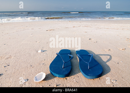 Coppia di sandali blu sulla sabbia a Holly spiaggia vicino Cameron, Louisiana sul Golfo del Messico. Foto Stock