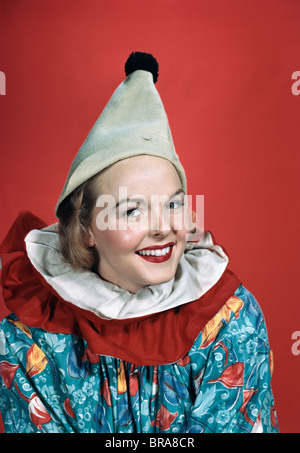 Negli anni quaranta anni cinquanta ritratto donna sorridente indossando CLOWN OUTFIT cappello appuntito pom pom collare increspato Foto Stock