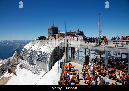 Il vertice del massiccio dello Zugspitze, Baviera, Germania, con ristoranti, piattaforme di visualizzazione e il cavo terminale auto su una soleggiata giornata estiva Foto Stock