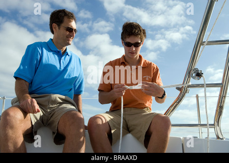 Insegnamento di padre di suo figlio come legare un nodo a bordo di un Hunter 49 yacht off sant Agostino, Florida, Stati Uniti d'America. Foto Stock