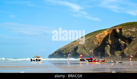 Surfers il riscaldamento su una spiaggia in Cornovaglia Foto Stock
