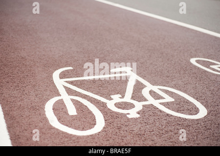 Ciclo designato Lane Simbolo, dipinta su un rosso manto stradale in asfalto, Brighton, Sussex, Inghilterra Foto Stock