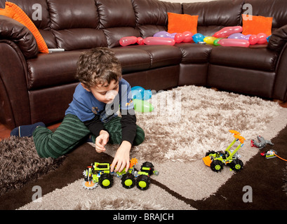 Bambini che giocano con i carrelli di plastica sul pavimento Foto Stock