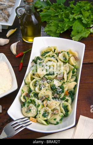 Orecchiette (poco le orecchie), un tipo di pasta della Puglia, con broccoli rabe e pesce salato (orecchiette con cime di rapa), Italia Foto Stock