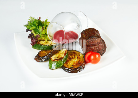 Arrosto di carne di manzo servita con sugo di carne alla griglia e le fette di melanzane e zucchini Foto Stock