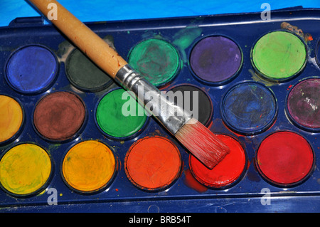 Colore dell'acqua / vernice colore pallet con pennello. Foto Stock