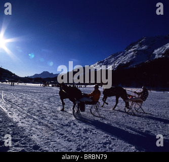 Tre fantini ice racing al fianco di una montagna in inverno Foto Stock