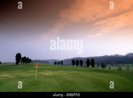 Bandiera sul green del golf si appoggia contro il vento sul corso deserta Foto Stock