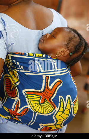 Madre africana che porta il suo bambino sulla schiena, Lomé, Togo, Africa occidentale Foto Stock