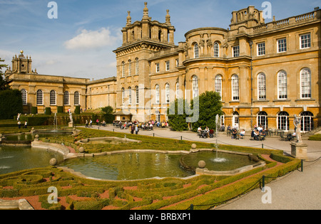 Turisti che si godono il sole di formali giardini presso il Palazzo di Blenheim, Oxfordshire. Foto Stock