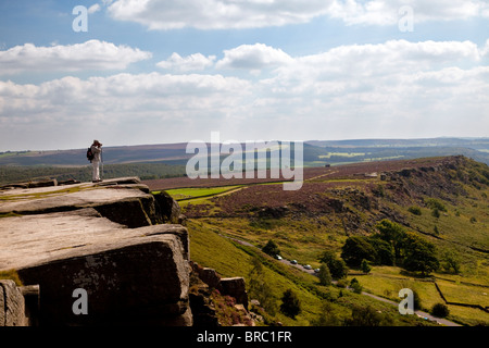 Persona in piedi sul bordo Curbar nel Parco Nazionale di Peak District Derbyshire England Regno Unito Foto Stock