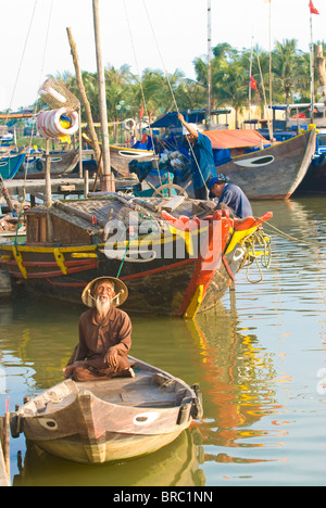 Tradizionalmente vestito vecchio seduto nella sua piccola barca da pesca, Hoi An, Vietnam, Indocina Foto Stock