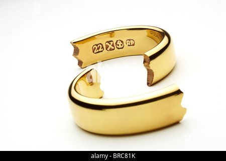 Oro rotto l'anello nuziale che simboleggiano il matrimonio si rompono Foto Stock