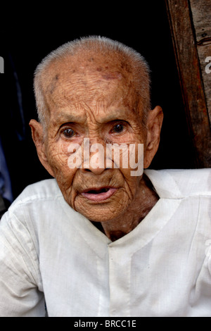 Un anziano femmina monaco buddista si trova all'ingresso alla sua abitazione a un tempio a Luang Prabang, Laos. Foto Stock