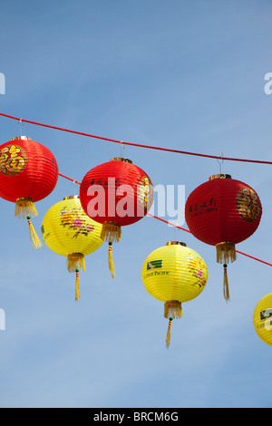 Rosso e giallo lanterne cinesi appeso contro un cielo blu Foto Stock