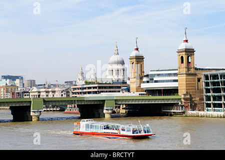 Una città turistica crociere in barca per visite guidate nei pressi di Southwark ponte ferroviario con St Pauls in background, London, England, Regno Unito Foto Stock