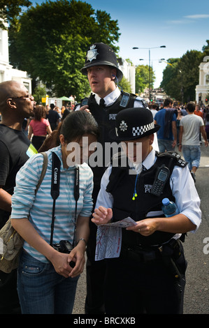 Gli ufficiali di polizia a dare indicazioni ai membri del pubblico al 2009 Notting Hill Cranival Foto Stock