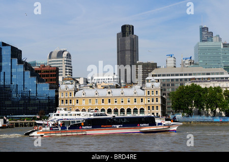 A Thames Clippers riverbus con la City di Londra edifici in background, London, England, Regno Unito Foto Stock