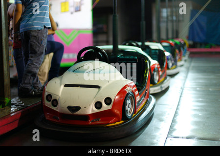 Svuotare il paraurti di automobili in un parco di divertimenti, mentre alcuni bambini attendere nelle vicinanze. Foto Stock