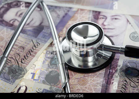 Stetoscopio medico su una pila di venti sterline banconote Foto Stock