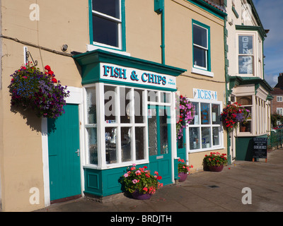 Un piccolo pesce e Chip shop luminosamente decorate con fioriere e cestini appesi Foto Stock