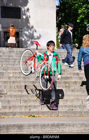 Uomo che porta bicicletta giù il Duca di York passi, il Centro Commerciale City of Westminster, Greater London, England, Regno Unito Foto Stock