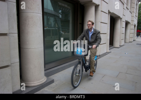 Equitazione sulla pavimentazione, Boris bike tfl biciclette a noleggio sponsorizzato da Barclays Bank, ciclista corre sul marciapiede. Foto Stock