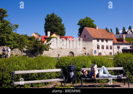 L'uomo sul banco in Almedalen park, Nella fortificata città anseatica di Visby, Gotland, che è sulla lista del patrimonio mondiale dell'UNESCO. Foto Stock