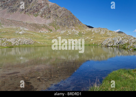 Il lago di Strino è un piccolo italiano lago alpino in Val di Sole, Trentino. Foto scattata con filtro polarizzatore Foto Stock