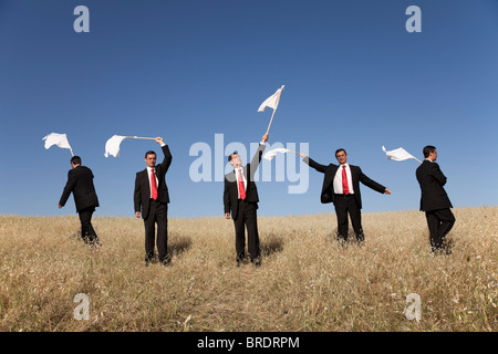 Gruppo di imprenditore nel campo alzare bandiera bianca Foto Stock