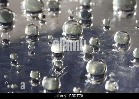 Gocce d'acqua sulla superficie cerata (vetro specchio) Foto Stock