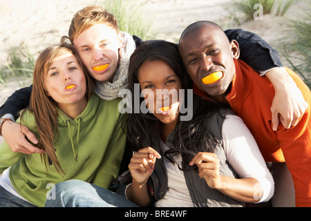 Gruppo di amici tirando funny faces sulla spiaggia Foto Stock