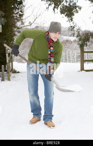 Giovane uomo la rimozione di neve da Drive Foto Stock