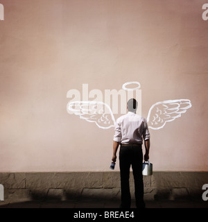 Uomo con ali d'angelo dipinta su una parete Foto Stock