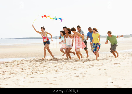 Gruppo di amici che corre lungo la spiaggia insieme Foto Stock