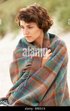 Giovane donna in piedi in Dune di sabbia avvolto in una coperta Foto Stock