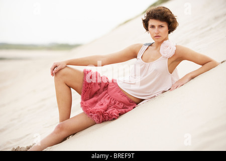 Vestiti alla moda attraente giovane donna in piedi tra le dune di sabbia Foto Stock