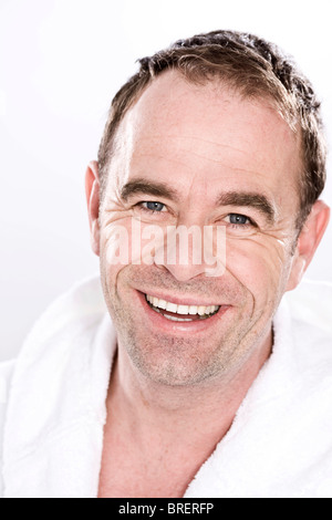 Ritratto di un uomo sorridente indossando un morbido accappatoio Foto Stock