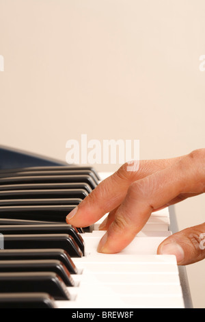 Primo piano di una mano che gioca su una tastiera di pianoforte con copyspace Foto Stock