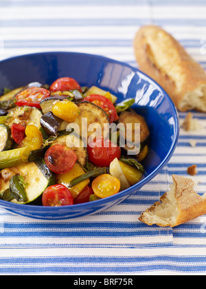 Ratatouille nella ciotola blu accanto a baguette, close-up Foto Stock