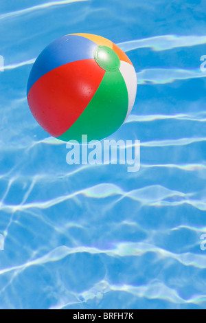 Beachball in un luminoso blu piscina Foto Stock