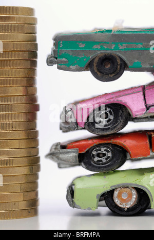 Rotto auto in miniatura e una pila di monete, immagine simbolica per il premio di demolizione Foto Stock