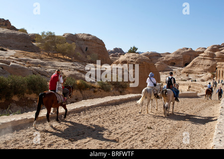 Turistico a cavallo di Siq, canyon ingresso alle antiche rocce scolpite città Petra, Giordania. Foto Stock